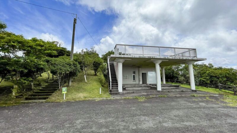 駐車場に白いコンクリート造りの建物がある